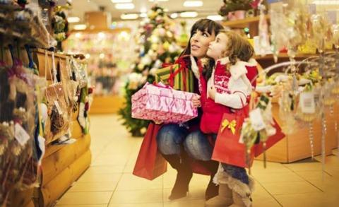Little Girl and Her mom looking at Christmas decorations in mall