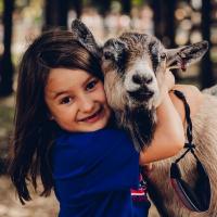 Little girl hugging a farm animal at Lucky Ladds Farms