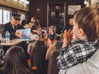 Kids gather around listening to the Train Conductor reading The Night Before Christmas